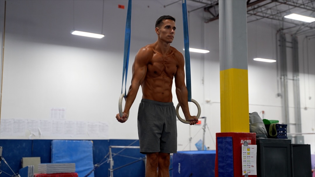 Adam holding a support hold on gymnastics rings